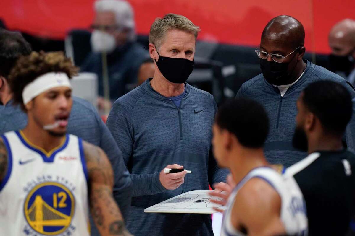 Golden State Warriors coach Steve Kerr holds a court diagram during the second half of the team's NBA basketball game against the Detroit Pistons, Tuesday, Dec. 29, 2020, in Detroit. (AP Photo/Carlos Osorio)
