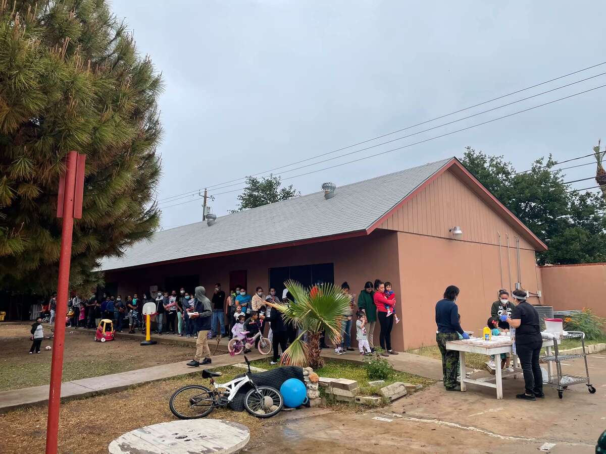 People wait in line for a meal distribution at the Holding Institute on May 1, 2021.