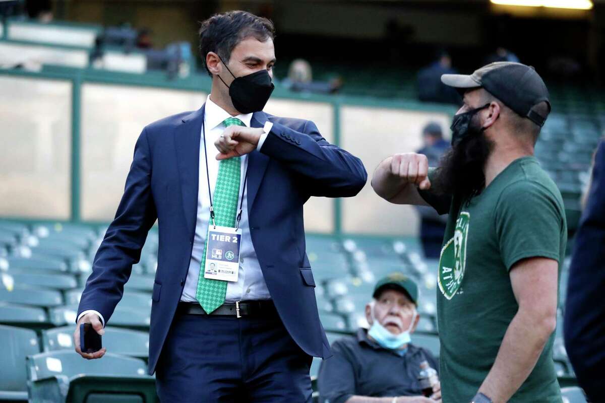 Oakland Athletics' president Dave Kaval elbow bumps a fan before A's play Houston Astros in season opener at Oakland Coliseum in Oakland, Calif., on Thursday, April 1, 2021.