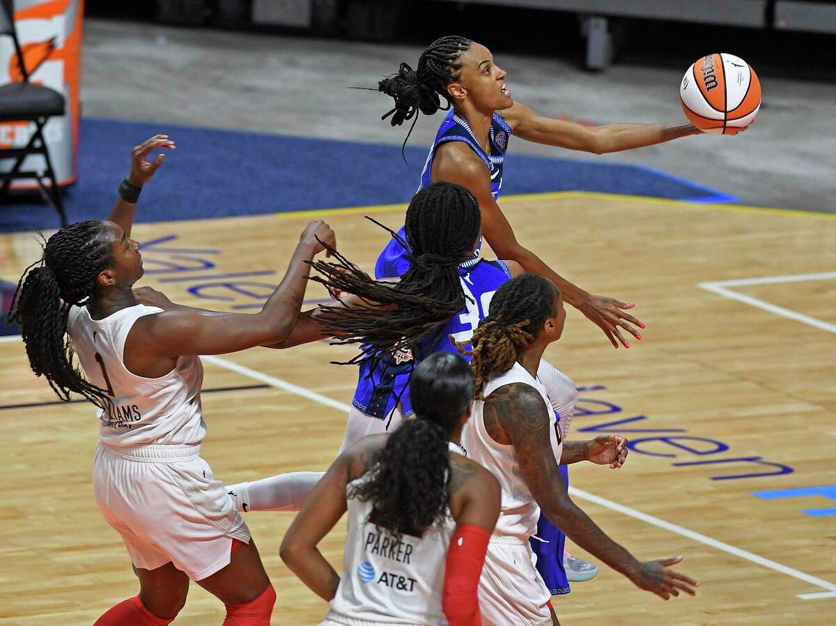 Connecticut Sun forward DeWanna Bonner glides to the basket ahead of Atlanta Dream defender Elizabeth Williams, left, and in front of teammate Jonquel Jones and Dream defenders Cheyenne Parker and Crystal Bradford during a WNBA basketball game Friday, July 9, 2021, in Uncasville, Conn. (Sean D. Elliot/The Day via AP)