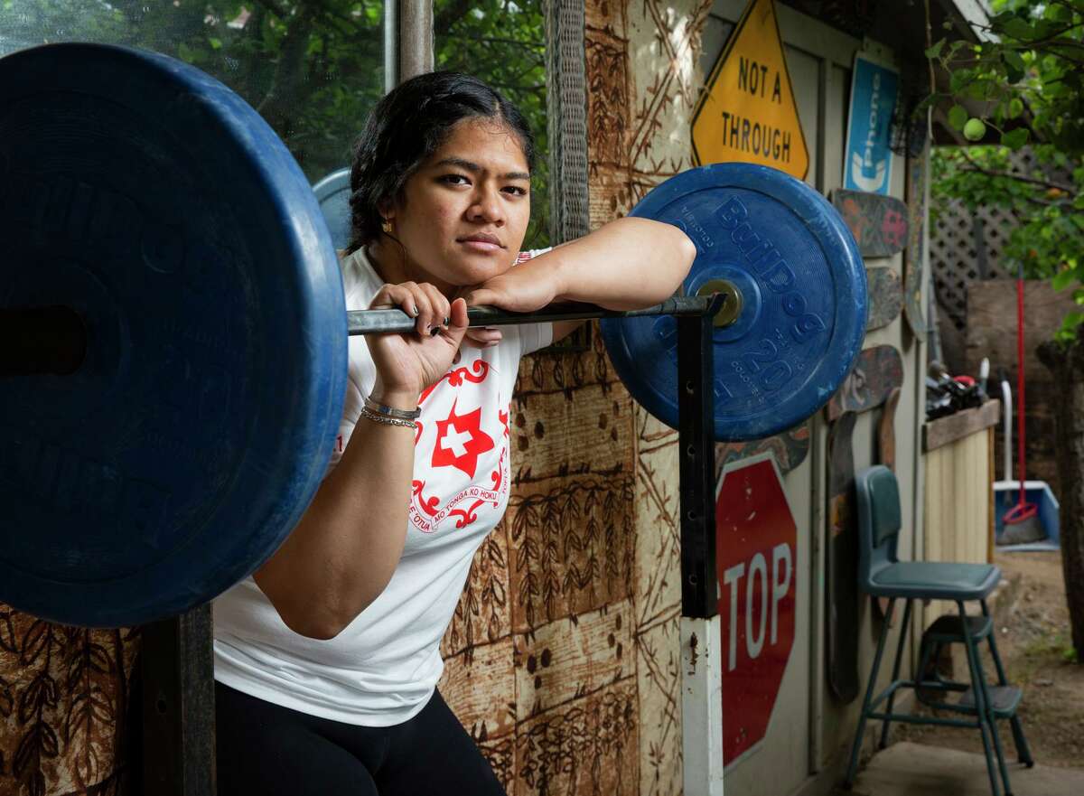 A portrait of Kuinini Manumua with weightlifting equipment in the backyard of her aunt, Wednesday, July 7, 2021, in San Bruno, Calif. Manumua, who also goes by the nickname Nini, will represent Tonga in women’s weightlifting in the Tokyo 2020 Summer Olympics. She trained in the backyard of her aunt’s home, as gyms closed during the coronavirus pandemic.