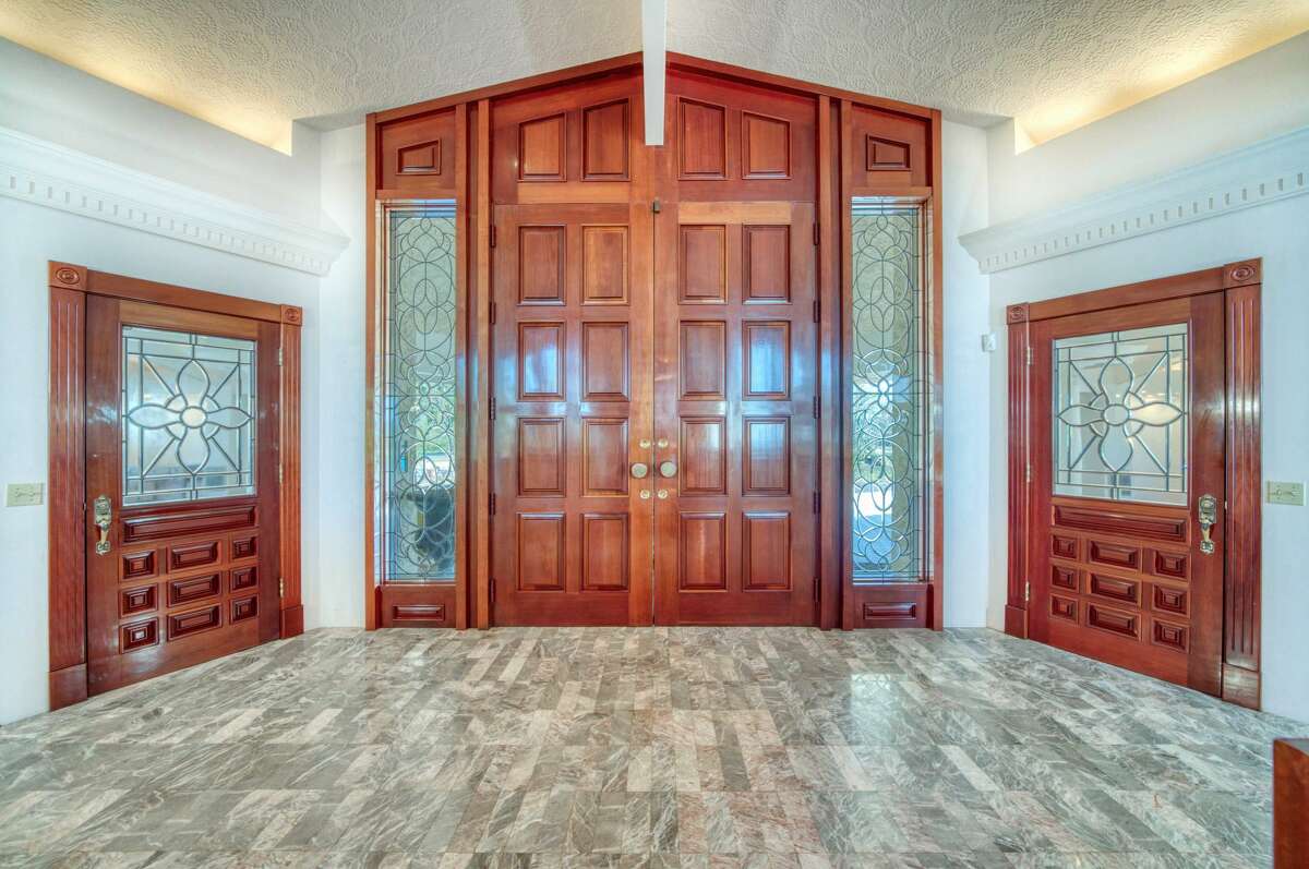 The entry door is of carved wood and the floor is marble. 