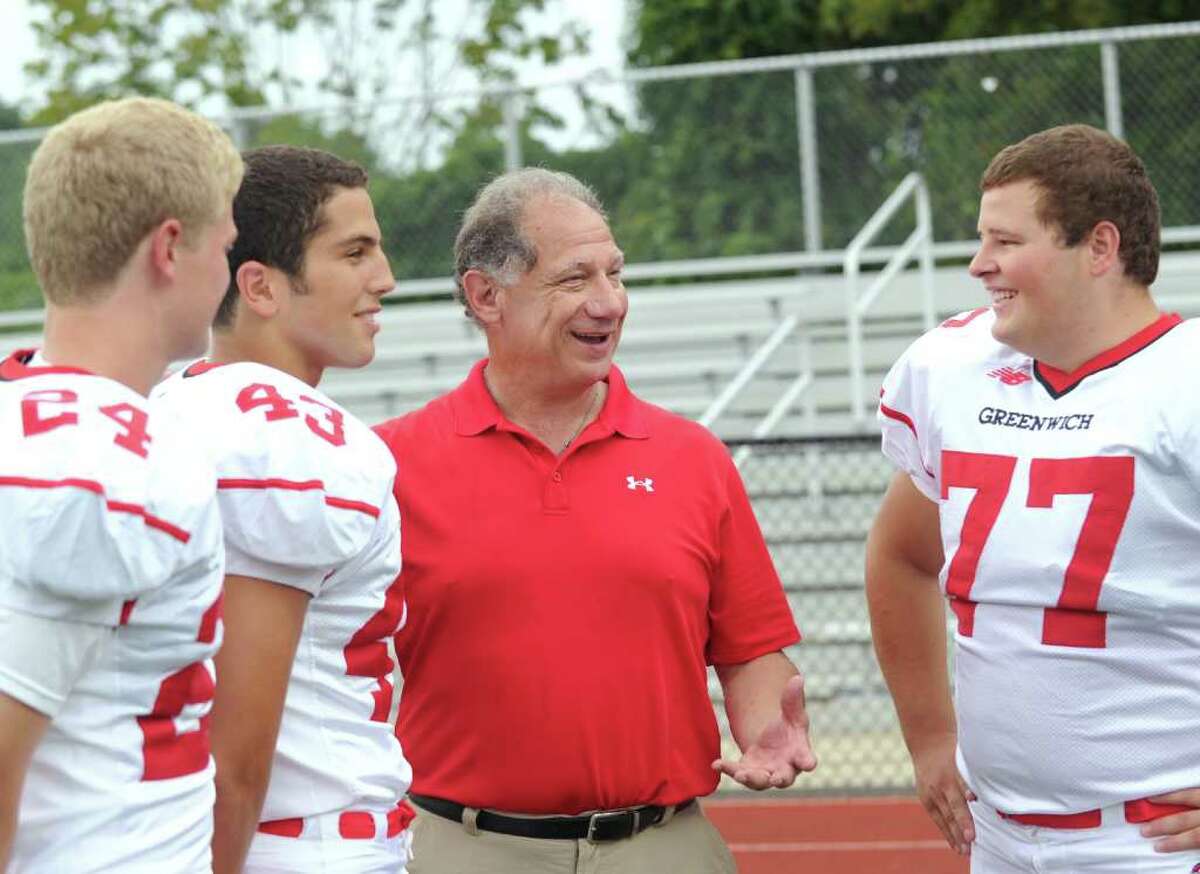 Greenwich High School football captains left to right, Peter Cabrera, Ben Ceci and Anthony Shepis, share a light moment with their coach, Rich Albonizio, during photo shoot day for the 2010 Greenwich High School Football team, at Cardinal Stadium, Friday, Sept. 3, 2010.