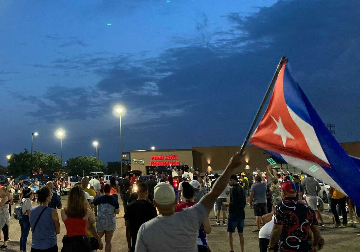 People gathered in the parking lot of PlazAmericas shopping mall to show support for Cubans facing food and medicine shortages.