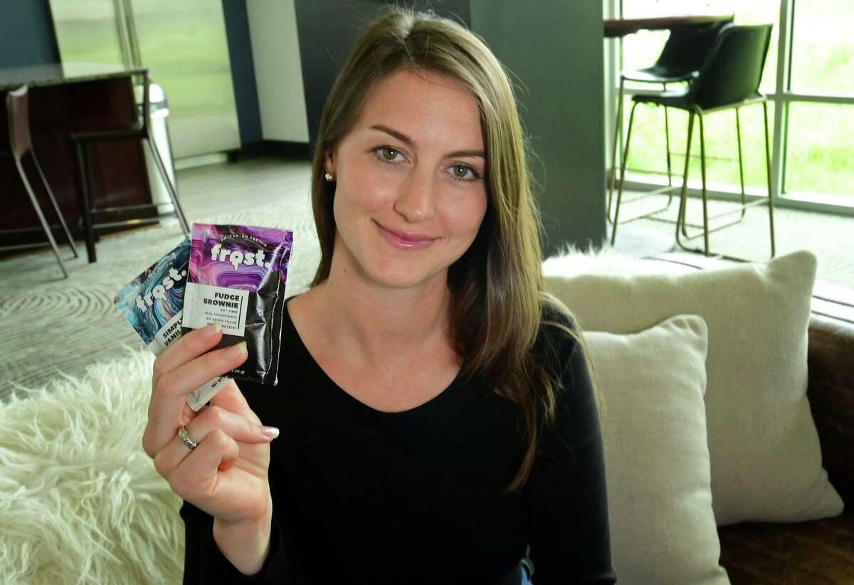 Alexa Ozimek with her new product in development, Frost, at her apartment Thursday, June 8, 2021, in Stamford, Conn. After a $10K Kickstarter campaign she is now readying the product testing. Frost is a protein-rich frosting snack you can eat right out of the pouch.