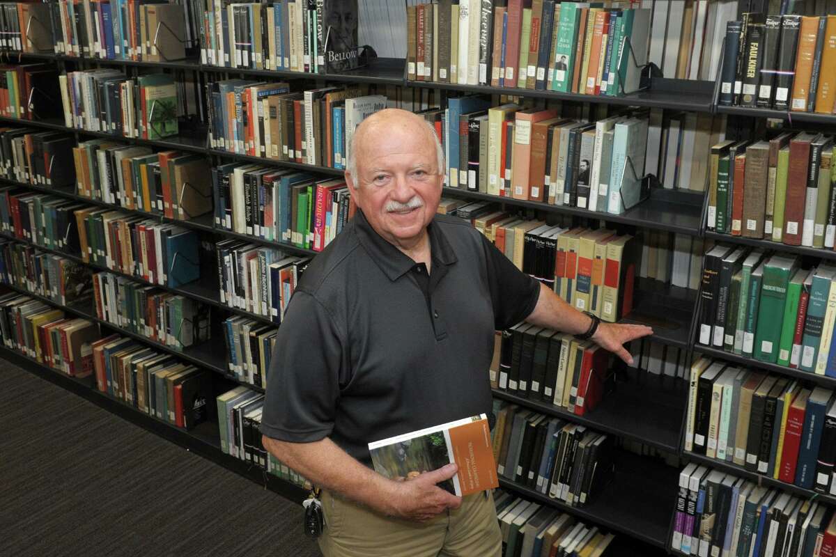 Edward Keane poses in the library of Housatonic Community College, in Bridgeport, Conn. July 8, 2021. Keane recently retired after 51-years as a professor at HCC.