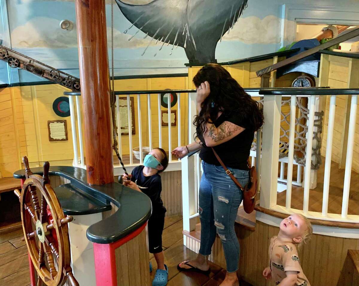 Jake Kochuk, 4, lowers the sail of a ship in the nautical-themed room at Kidcity Children's Museum in Middletown while his mother, Meaghan and 1-year-old brother, Miles, look on.