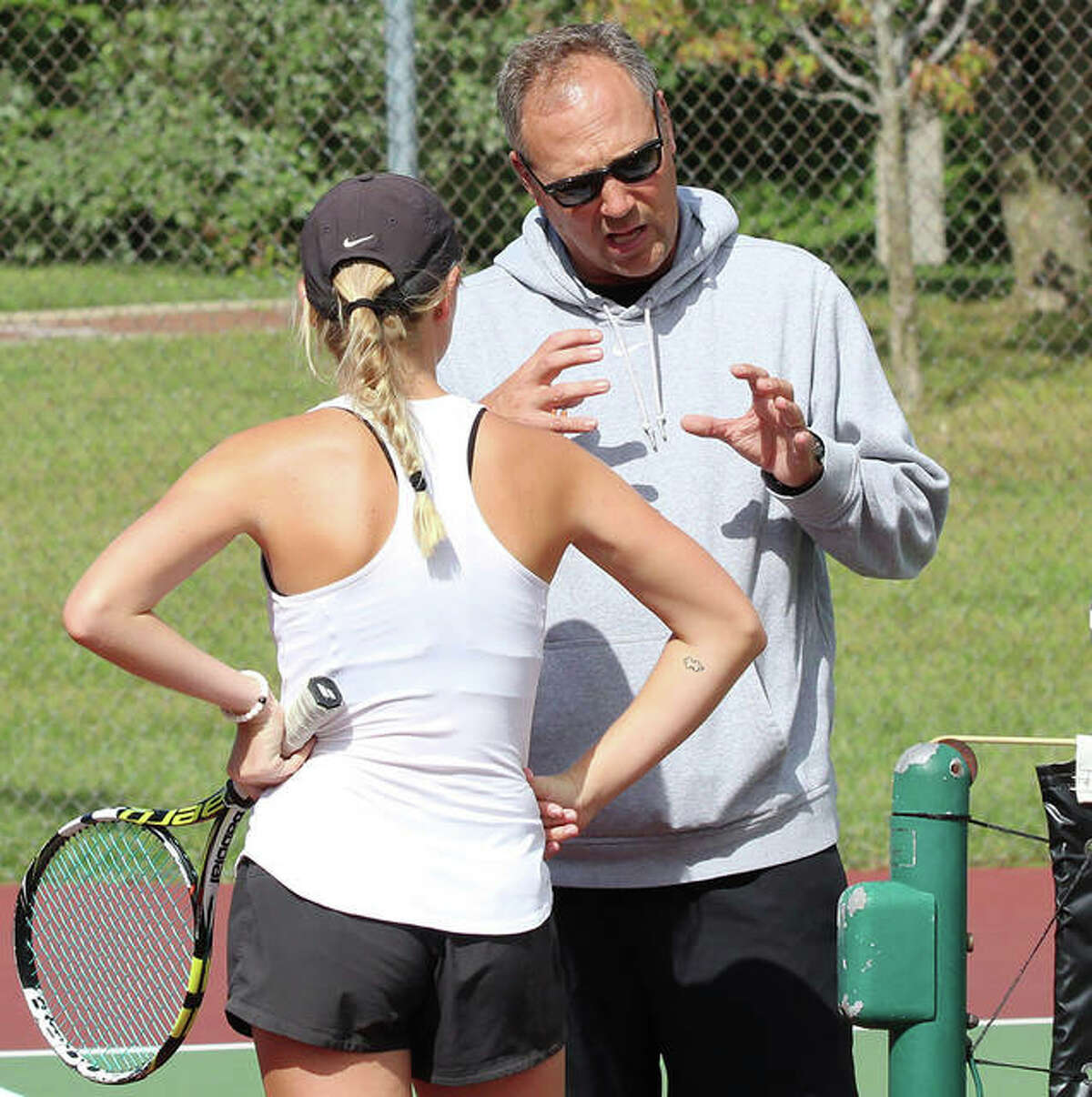 Edwardsville High School tennis coach Dave Lipe (right), shown talking with Annie McGinnis during a break in a doubles match.