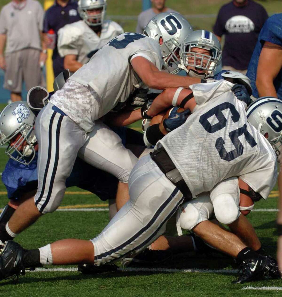 Staples' #65 Mike Nicholaus, in front, and #83 Chris Coyne, left, take down Bunnell's Josh Diaz, during football scrimage action in Stratford, Conn. on Wednesday September 1, 2010.