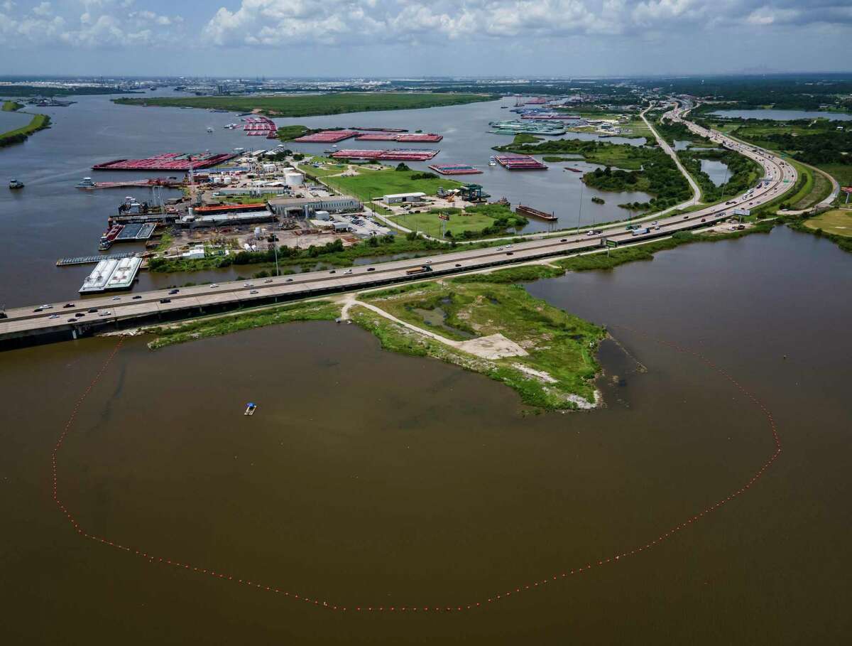 A line of buoys marks the boundary of the northern impoundments of the San Jacinto Waste Pits just north of Interstate 10 on the San Jacinto River, Tuesday, July 13, 2021, in Channelview. The southern impoundments of the superfund site are on the small peninsula south of the freeway.