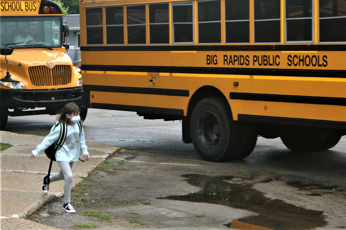 In this Aug. 27, 2020 Pioneer file photo, a masked Riverview Elementary student walks to the bus after school. Big Rapids parents and students advocated for a regulation-free school year during this week's board meeting meeting. 