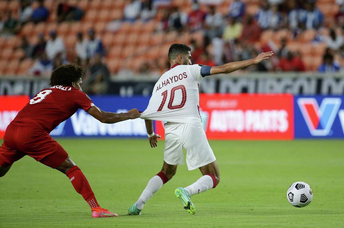 Panama midfielder Adalberto Carrasquilla (8) pulls on the jerseys of Qatar forward Hassan Al-Haydos (10) during the first half of a CONCACAF Gold Cup group stage match at BBVA Stadium on Tuesday, July 13, 2021, in Houston.