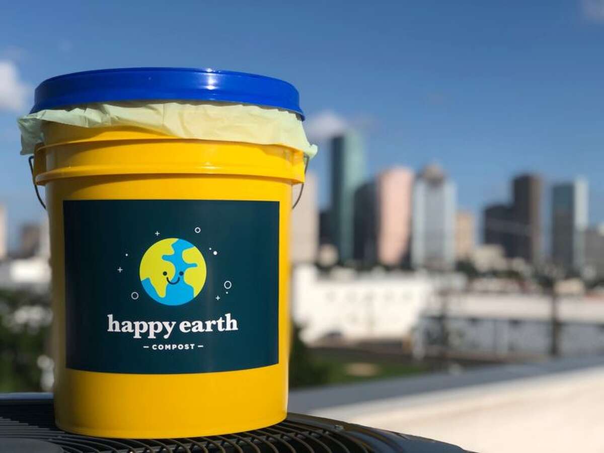 Happy Earth Compost's outdoor compost bucket against Houston's skyline.