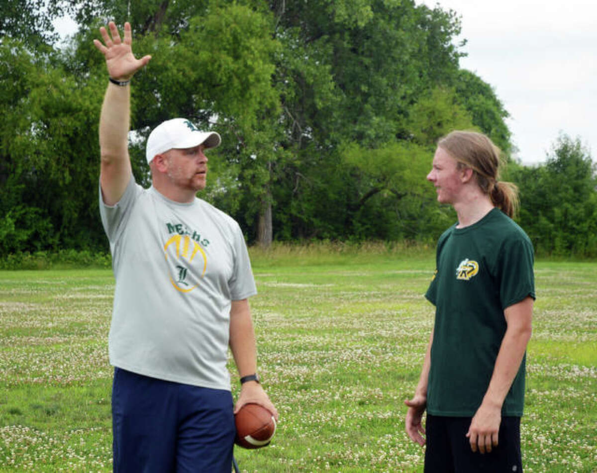 Metro-East Lutheran football coach Mike Koch, left, talks to senior Kaiden Downs during a practice session at MELHS last week.
