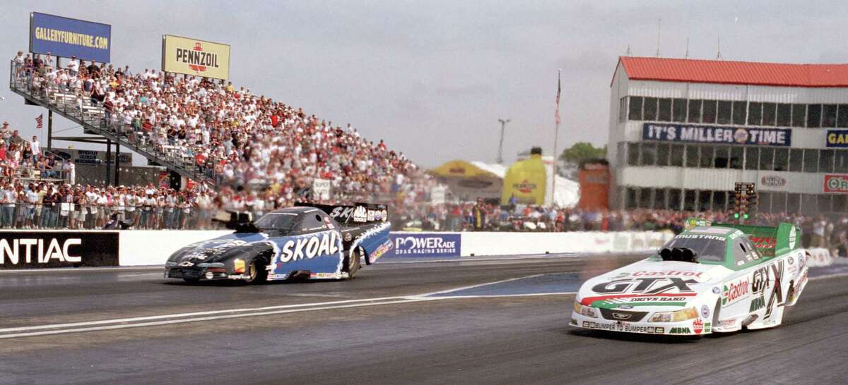 Funny car driver John Force at right gets his 100th career win against Tommy Johnson Jr. in the finals the NHRA O'Reilly Nationals at Houston Raceway Park in Baytown in 2002.