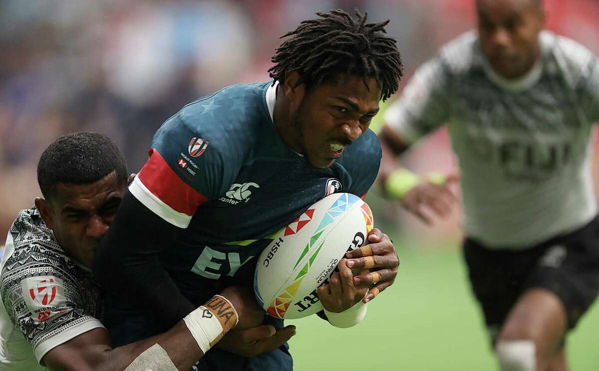 VANCOUVER, BRITISH COLUMBIA - MARCH 08: Kevon Williams #6 of USA scores a try while dragging Apenisa Cakaubalavu #5 of Fiji during their rugby sevens match at BC Place on March 08, 2020 in Vancouver, Canada. (Photo by Trevor Hagan/Getty Images)