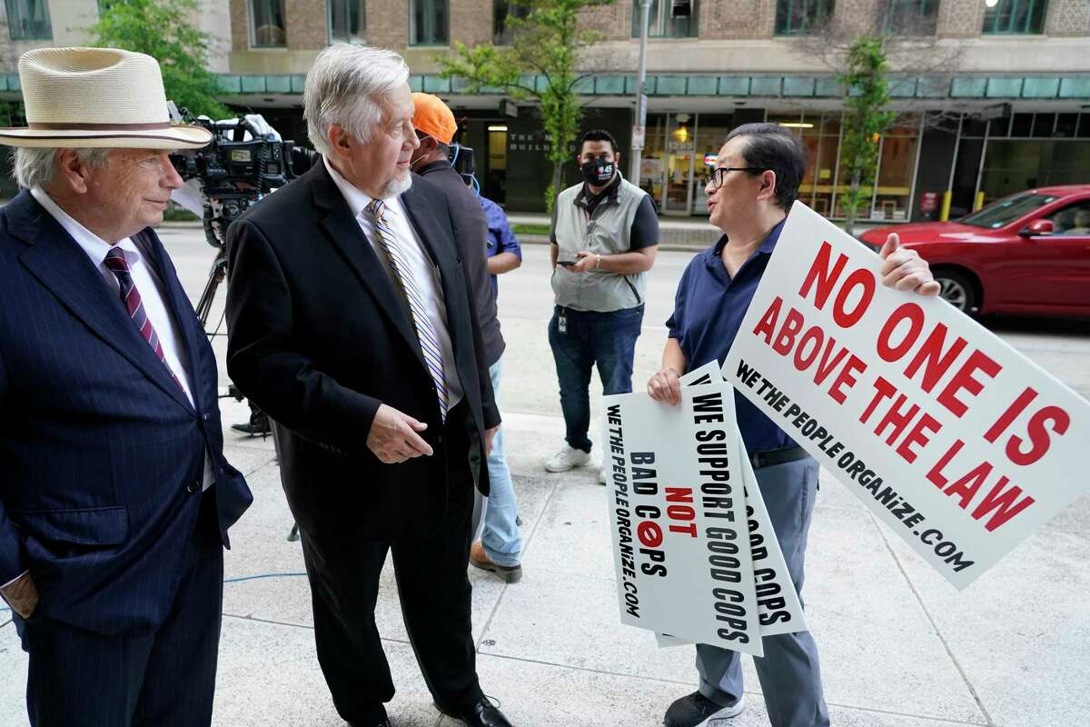 Attorneys Mike DeGeurin, left, and Randall Kallinen, center, talk with Hai Bui, with We The People Organize, right, before a press conference held outside the Houston Police Dept., 1200 Travis, Wednesday, July 14, 2021 in Houston. The press conference was about the federal civil rights verdict against a former HPD officer and a current officer stemming from a 2017 traffic stop of their client Jose Gomez.