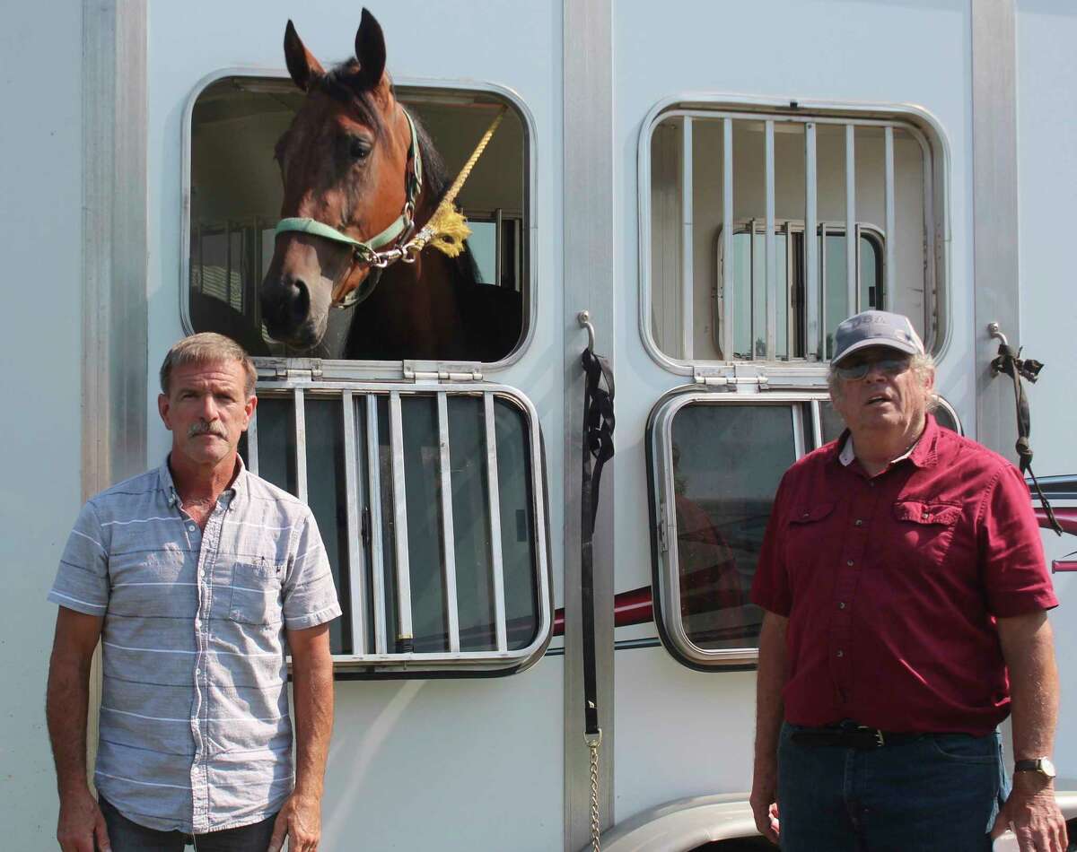 Dan Hoffman, left, and Randy McConnell pose with their horse, Secret Stash, prior to Wednesday's grandstand race event at the Mecosta County Fair. (Pioneer photo/Joe Judd) 