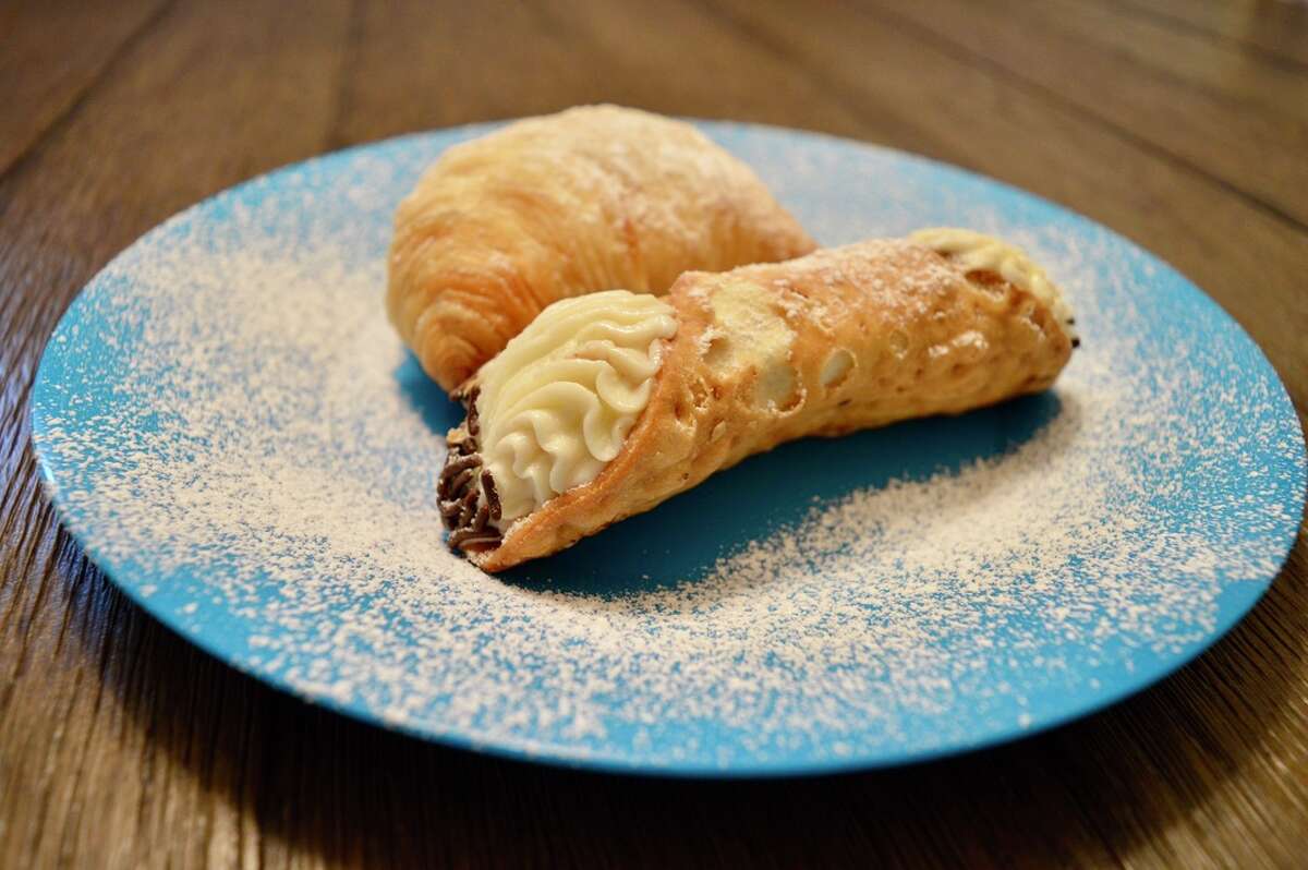 A traditional Italian cannoli (foreground) and sfogliatelle (background) from Libby's Italian Pastry Shop in New Haven, Conn. on Wednesday, July 14, 2021. 