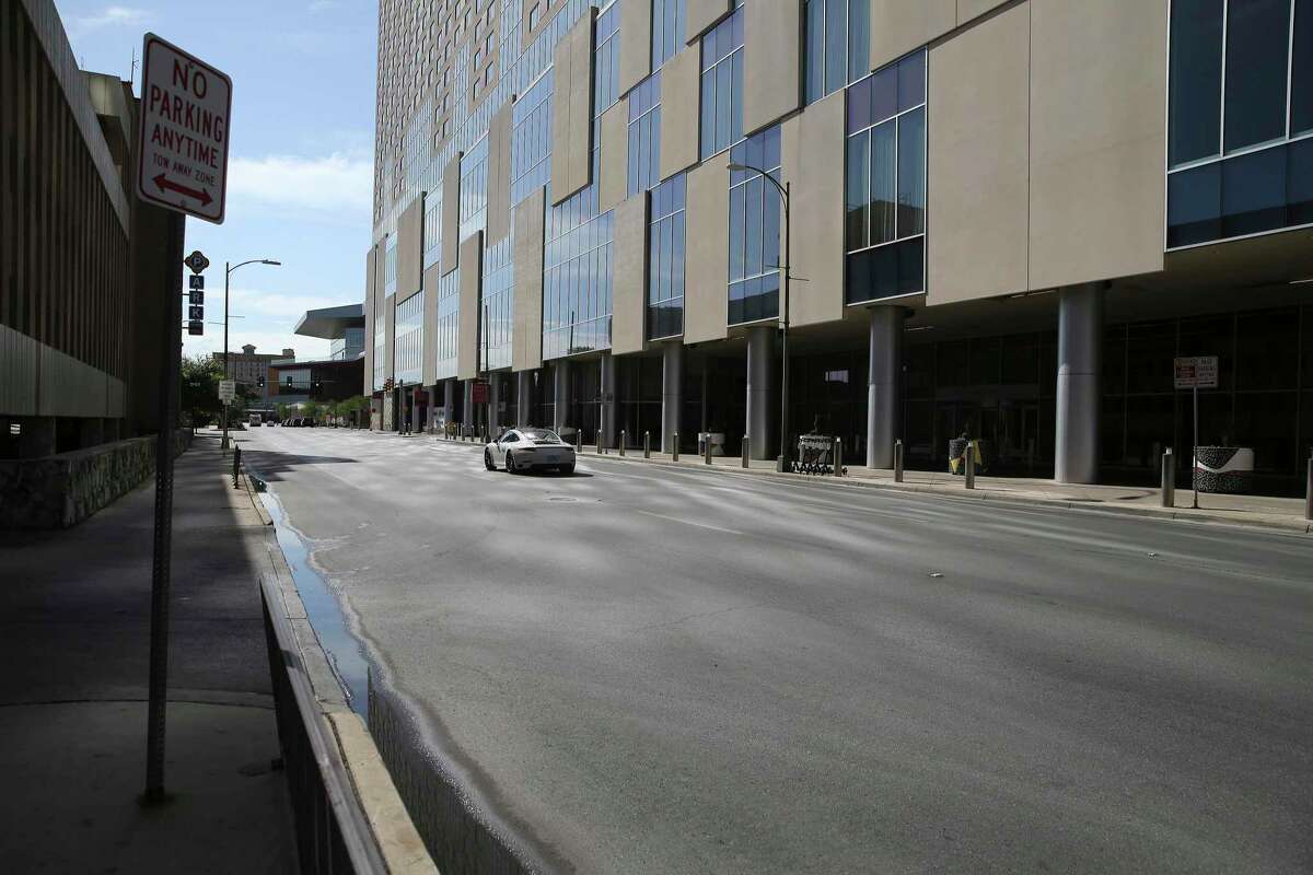 A lone vehicle zips down Houston Street near the Grand Hyatt near the Henry B. Gonzalez Convention Center on May 14, 2020. From the early days of the COVID-19 pandemic, convention cancellations began piling up and hotel reservations were suffering.