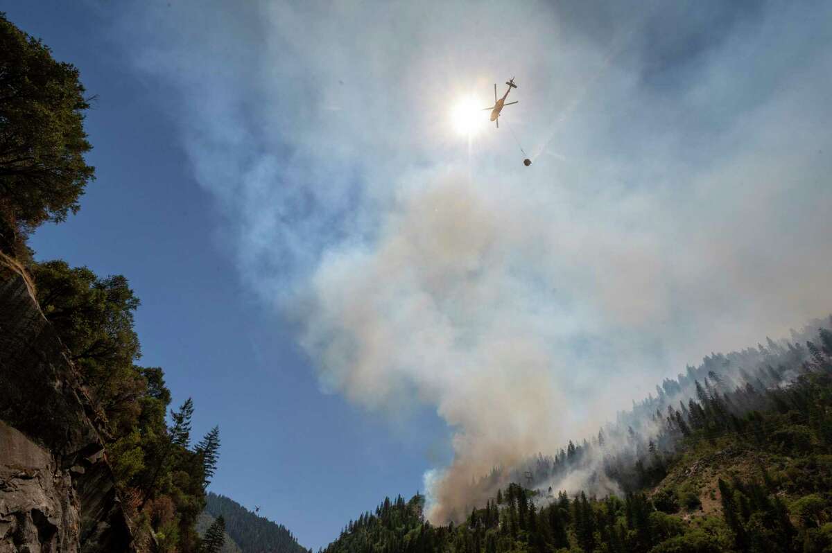 Helicopters drop water to battle the Dixie Fire on Highway 70 in the Feather River Canyon in Plumas County.