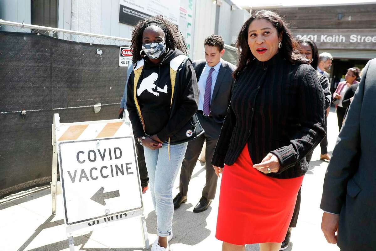 San Francisco Mayor London Breed leads Tianna Hicks, mother of NFL rookie Najee Harris, to get a COVID vaccination at Southeast Health Center in the Bayview neighborhood of San Francisco.