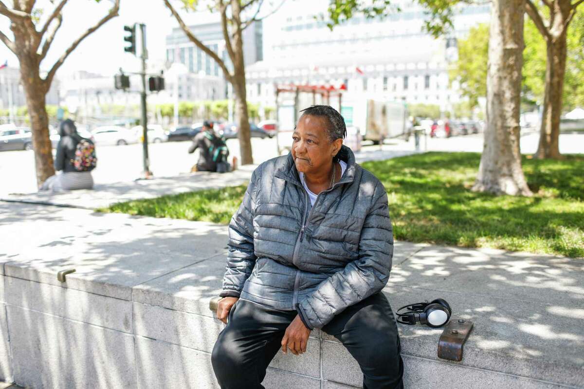 Pamela Tisdale waits for the bus as she runs errands in San Francisco. Tisdale lives in a hotel that has been temporarily leased by the city for homeless people during the pandemic. She said she has to deal with rats on a daily basis, and also had to recently vacate her room when a pipe burst.