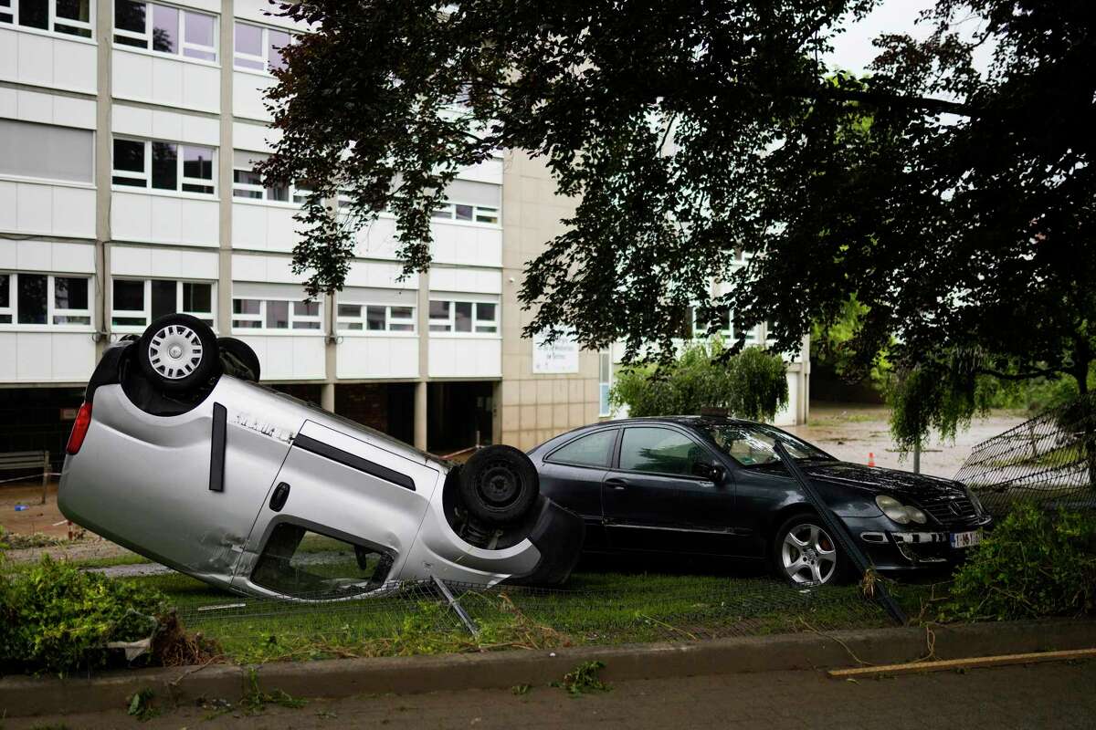 A damaged car lays on its roof on the roadside after flooding in Ensival, Verviers, Belgium, Friday July 16, 2021. Severe flooding in Germany and Belgium has turned streams and streets into raging torrents that have swept away cars and caused houses to collapse.