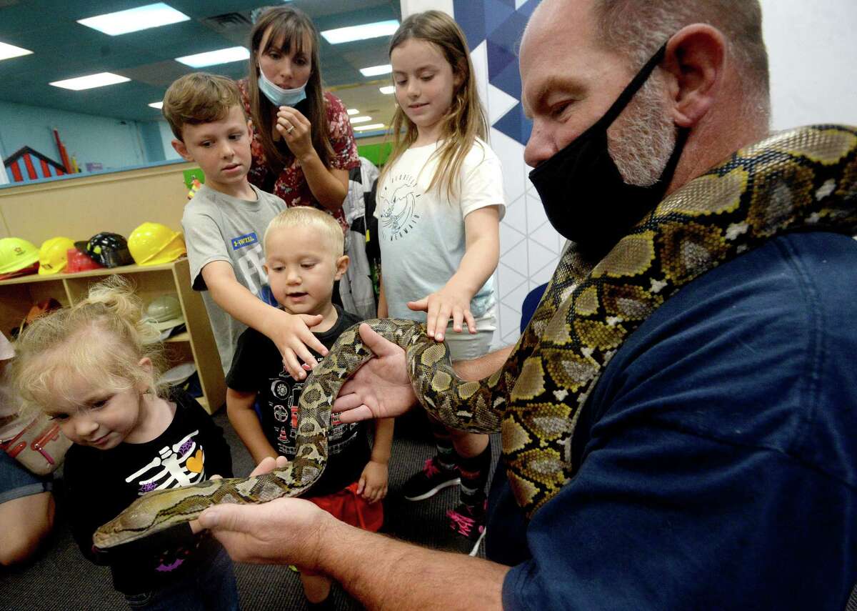 Kevin Williams holds his python Pogo as children move in to get an up close experience at the Beaumont Children's Museum Thursday morning. Photo taken Thursday, September 24, 2020 Kim Brent/The Enterprise