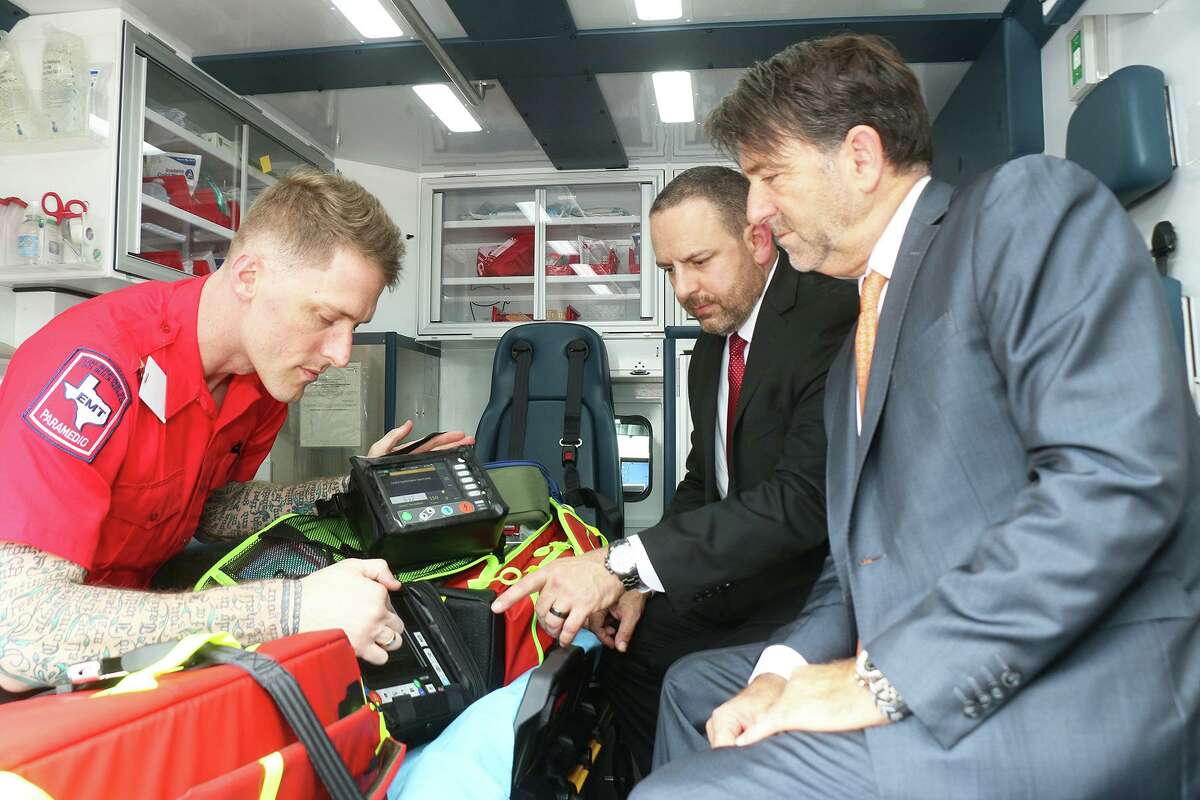 CCEMS Paramedic Joseph Wells demonstrates critical care equipment to American Jet International CEO Roger Woolsey in the bay of the ambulance while CCEMS CEO Wren Nealy, Jr. looks on. The two organizations signed a contract to work together for critical care medical transport services and organ procurement operations across the country and around the globe.