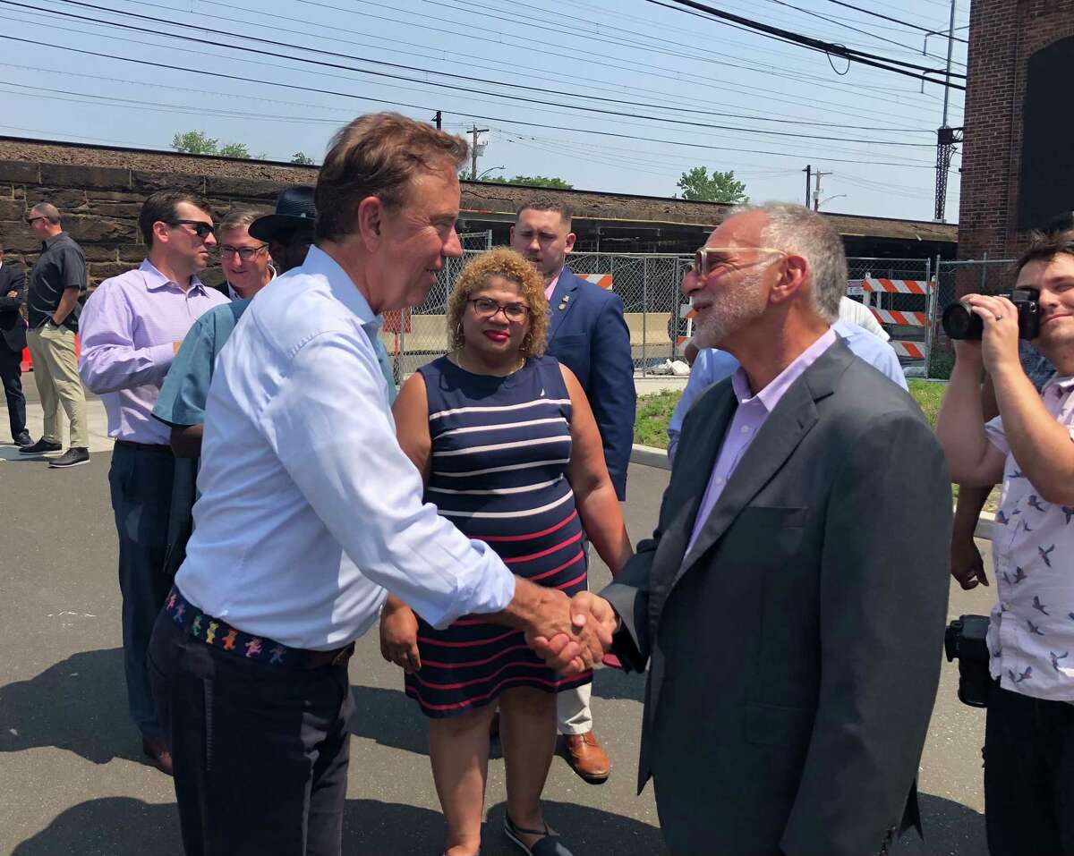 Govl Ned Lamont shakes hands with developer Gary Flocco before a groundbreaking ceremony at the Cherry Street Lofts in Bridgeport, Conn. July 16, 2021.