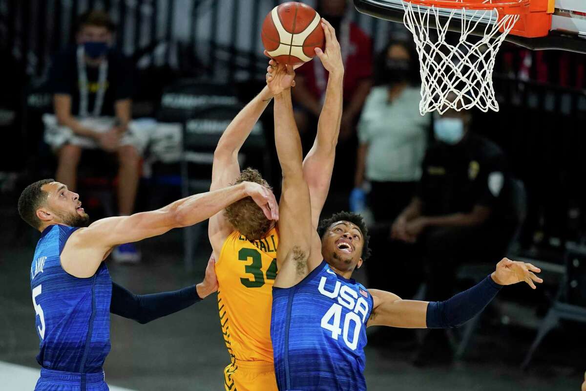 United States' Zach LaVine, left, and Keldon Johnson, right, battle for a rebound with Australia's Jock Landale during an exhibition basketball game Monday, July 12, 2021, in Las Vegas. (AP Photo/John Locher)