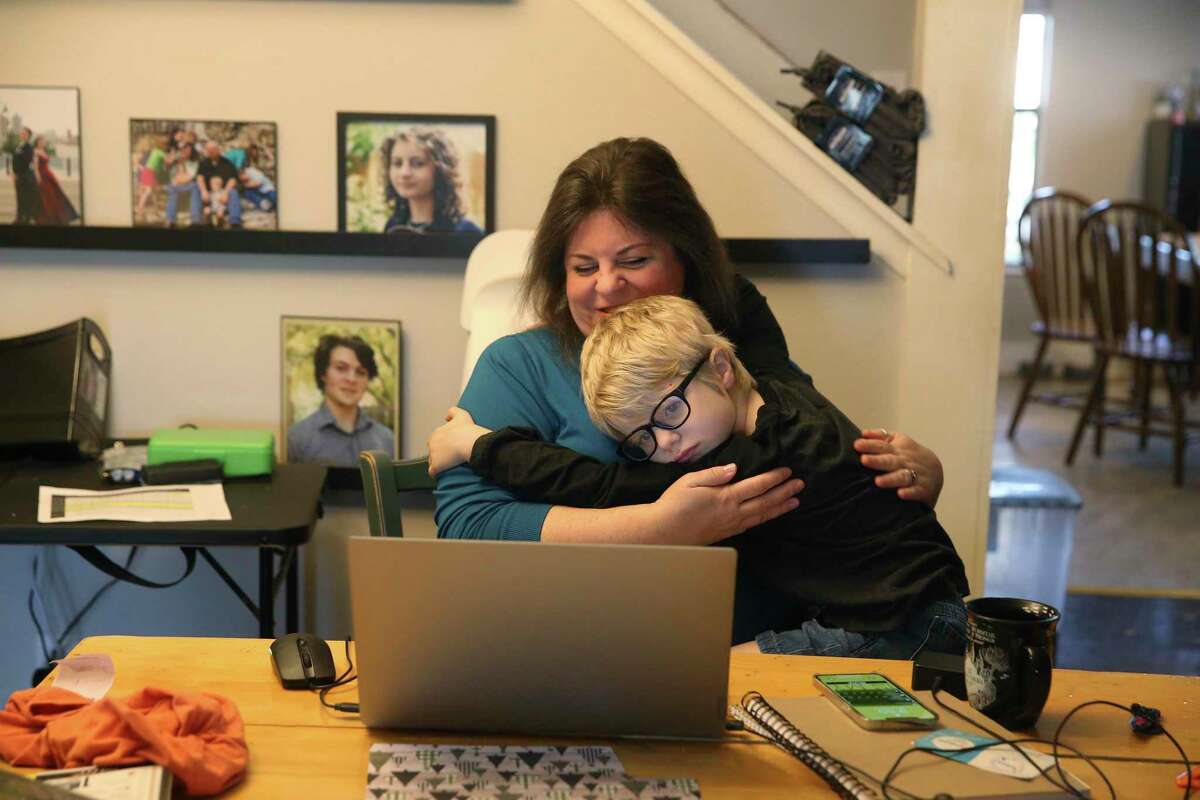 Simon Ryan gets a hug from his mother, Sheila, before the start of home-based learning from Great Hearts Online.