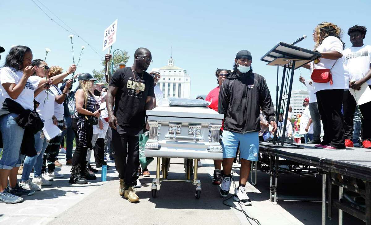 在7月10日举行的“为安全的奥克兰站起来”反暴力集会上，一些参加者抬着棺材，代表在该市枪支暴力中丧生的人。许多与会者向人群讲述了因枪支暴力而缩短的亲人的生活。