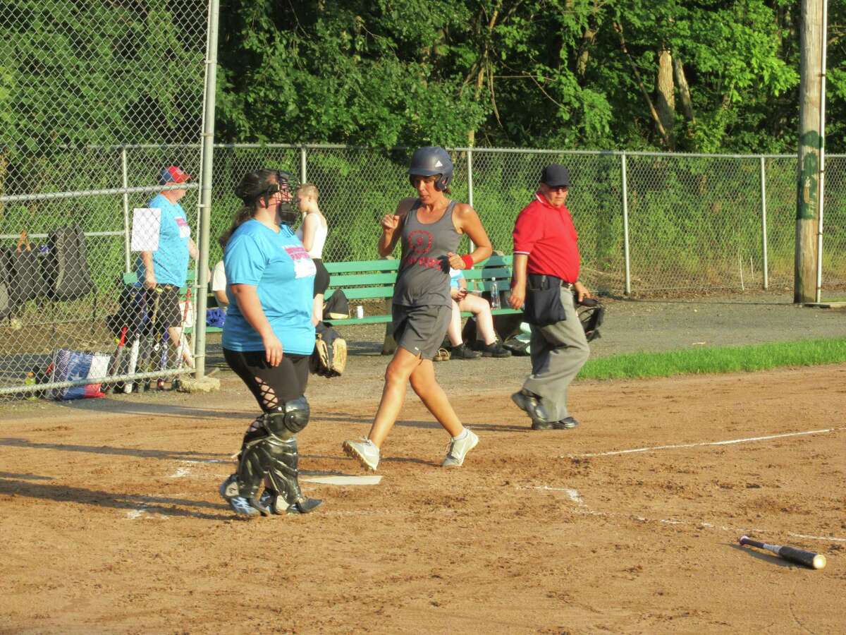 Stephanie Maxwell scores for her Sawyer’s Girls team in the Torrington Parks and Recreation Softball League as Torrington Downtown Partners/USA Hauling catcher Linda Lafferty-Cerruto waits for another chance Thursday evening at Joe Ruwet Park.