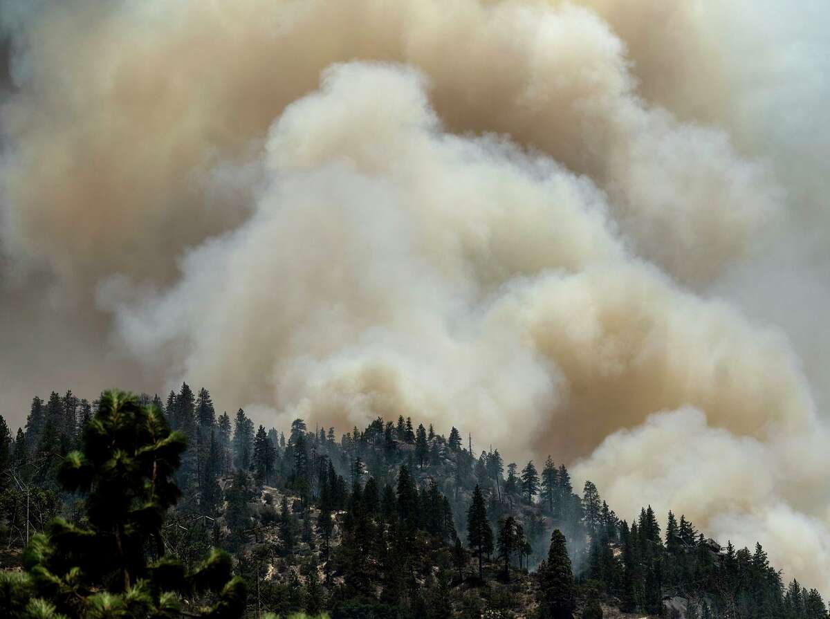 Smoke rises Friday from the Dixie Fire burning along Highway 70 in Plumas National Forest. The Department of Homeland Security announced Saturday that its immigration enforcement force wouldn’t conduct operations at wildfire evacuation centers.