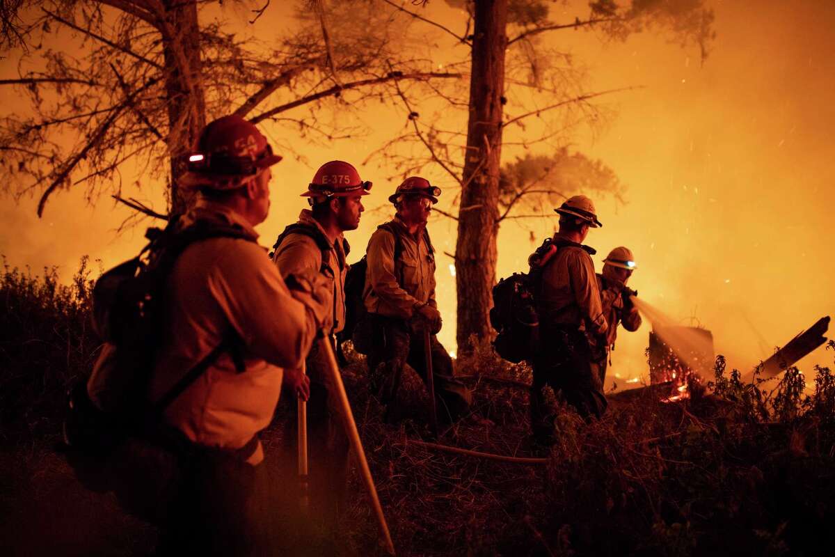 Cal Fire fighters and U.S. Forest Service firefighters battle a wildfire on the south coast of Big Sur, near Lucia (Monterey County), in August 2020.