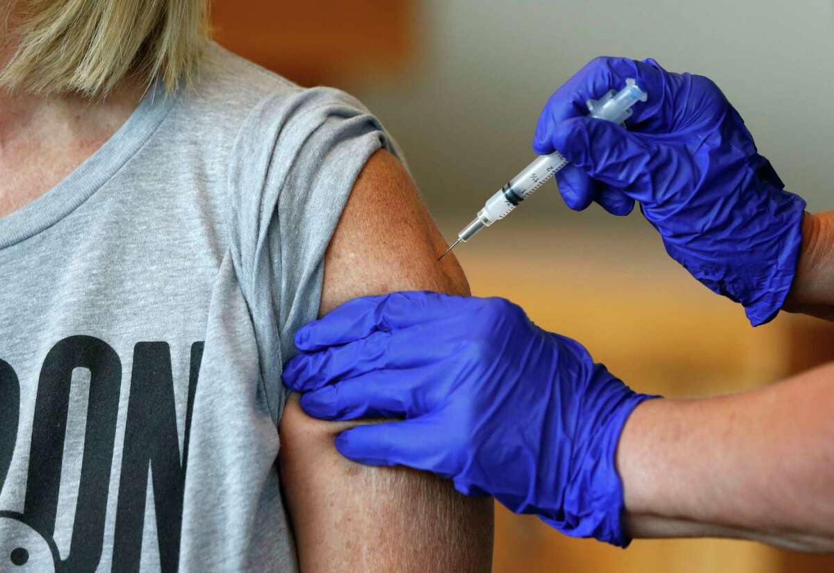 FILE - In this Monday, July 12, 2021 file photo, Karen Martin receives a COVID-19 vaccine at a vaccination clinic hosted by James River Church West Campus in conjunction with Jordan Valley Community Health Center in Springfield, Mo. The U.S. surgeon general said Sunday, July 18 that he's concerned about what lies ahead with cases of COVID-19 increasing in every state, millions still unvaccinated and a highly contagious virus variant spreading rapidly. (Nathan Papes/The Springfield News-Leader via AP, File)