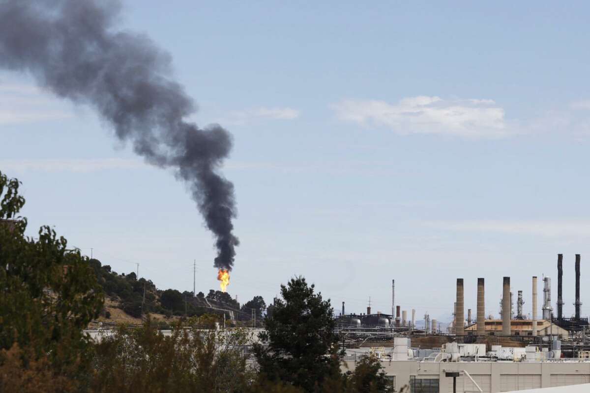 Smoke and flames shoot from a building after a release of chemicals at the Chevron oil refinery in Richmond in August.