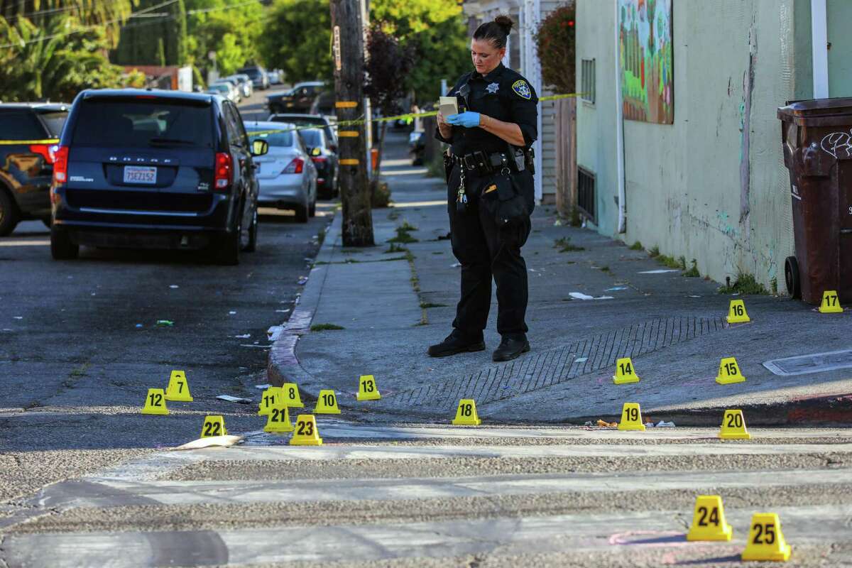 An officer investigates a fatal June shooting in Oakland, where money is being shifted from police to violence prevention.
