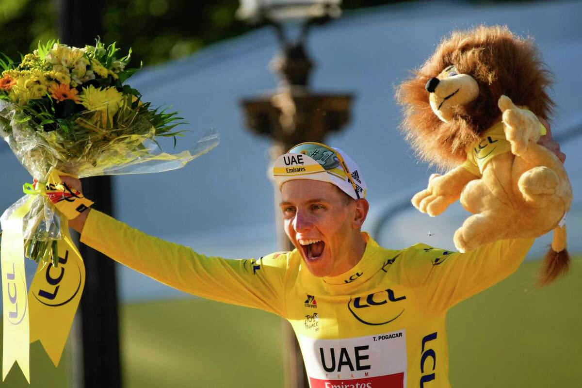 Slovenian cyclist Tadej Pogacar celebrates on the podium in Paris after the 21st and final stage of the Tour de France.