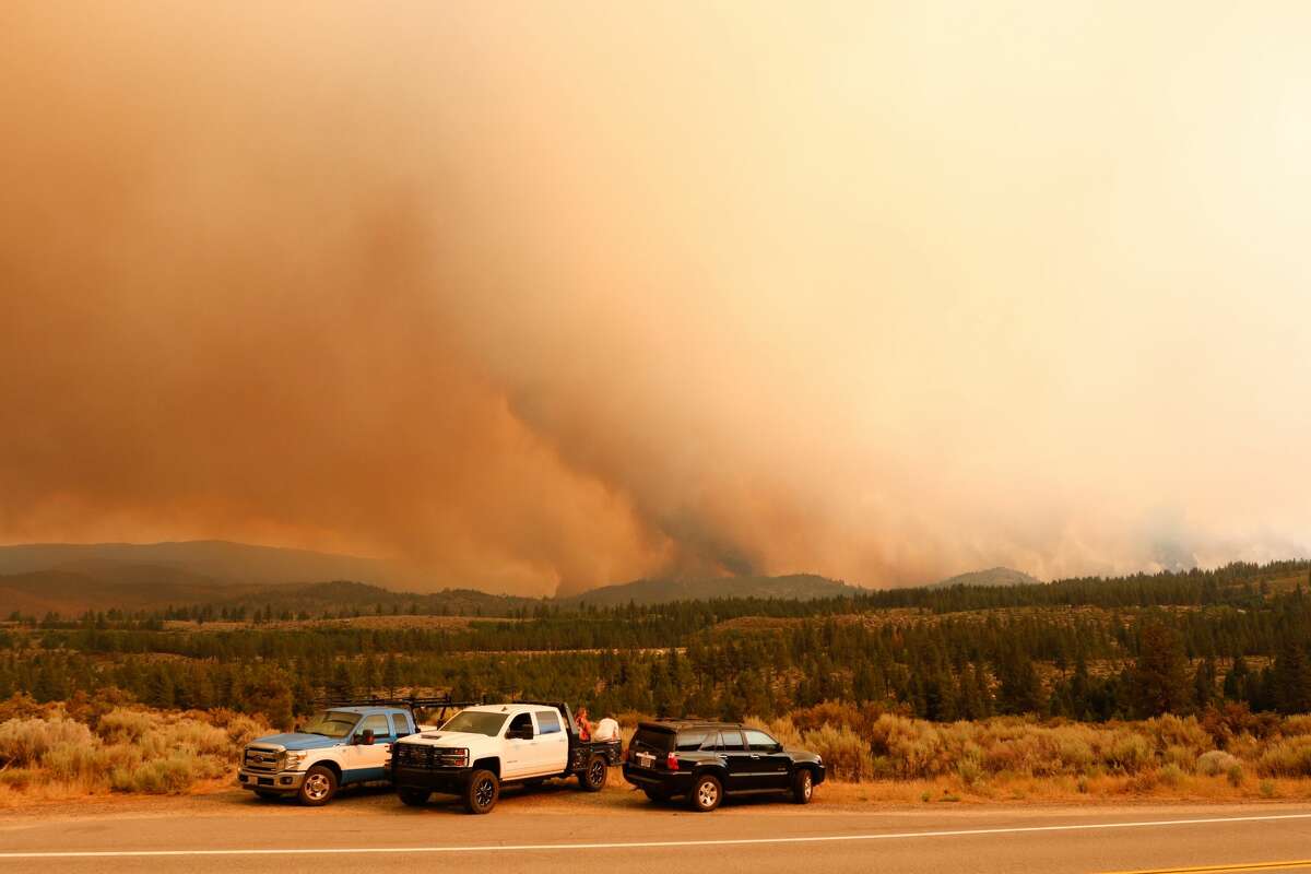 People watch as the Tamarack fire burns unchecked due to drought conditions and gusty winds. The Tamarack fire continues to burn through more than 21,000 acres and is currently 0% contained. 