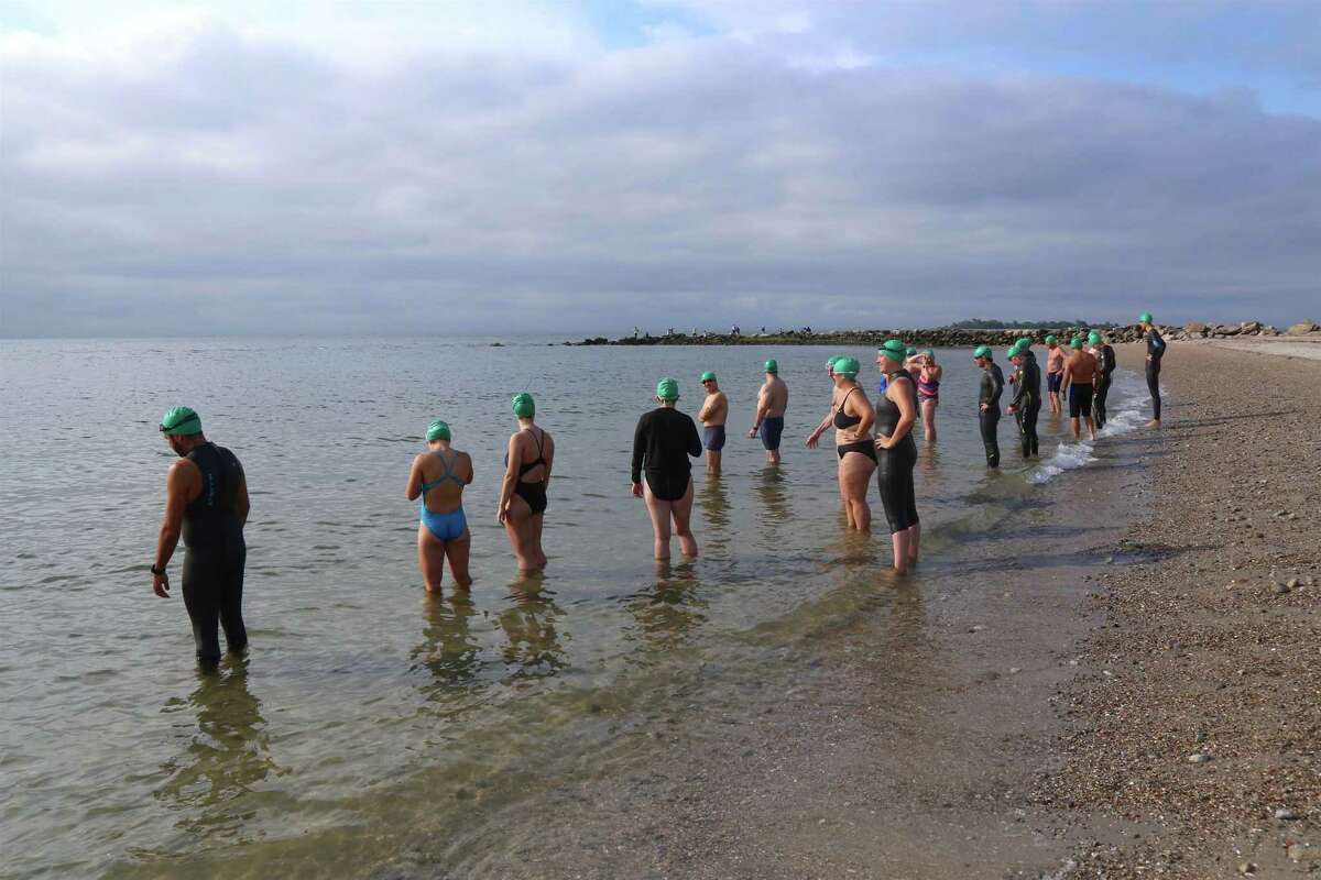 Intermediate swimmers wearing green caps prepare to enter the water at the Point to Point Swim at Compo Beach on Sunday, July 18, 2021, in Westport, Conn. But in the home stretch, the opposite became true and a shortened stroke, using more effort, became necessary to keep moving. "You're halfway through the race and then it gets more difficult," said Sargent, who began competitive racing 48 years ago at age six and participated in his first Point to Point Swim in 1983. "But the conditions were beautiful, just beautiful," he said.