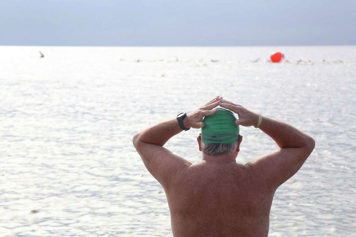 Attila Libertiny of South Salem, N.Y., watches the first group of swimmers round the buoy at the Point to Point Swim at Compo Beach on Sunday, July 18, 2021, in Westport, Conn. Others came out for their first time, including Shelley Forrester of Westport, who has been improving her stroke with adults lessons at the Y. "I'm a little nervous," she admitted, heading up the beginner's heat. "It's a great community event," said Denise Hotch, fitness coordinator at the Y. "And it's a fundraiser for people in our community who otherwise couldn't afford memberships."