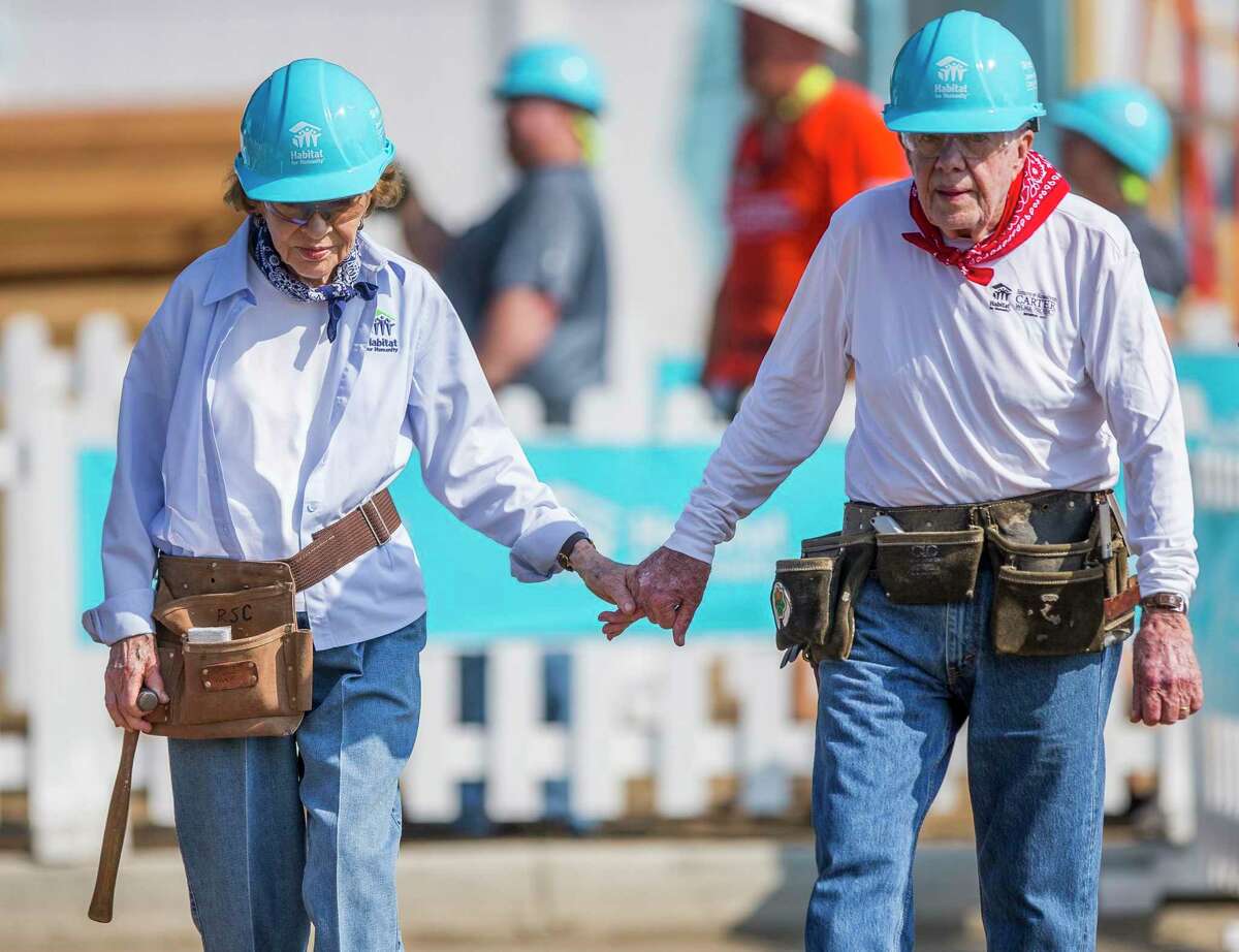 Former President Jimmy Carter holds hands with his wife, former first lady Rosalynn Carter, as they work in August 2018 with other volunteers on site during the first day of the weeklong Jimmy & Rosalynn Carter Work Project, their 35th work project with Habitat for Humanity in Mishawaka, Ind.