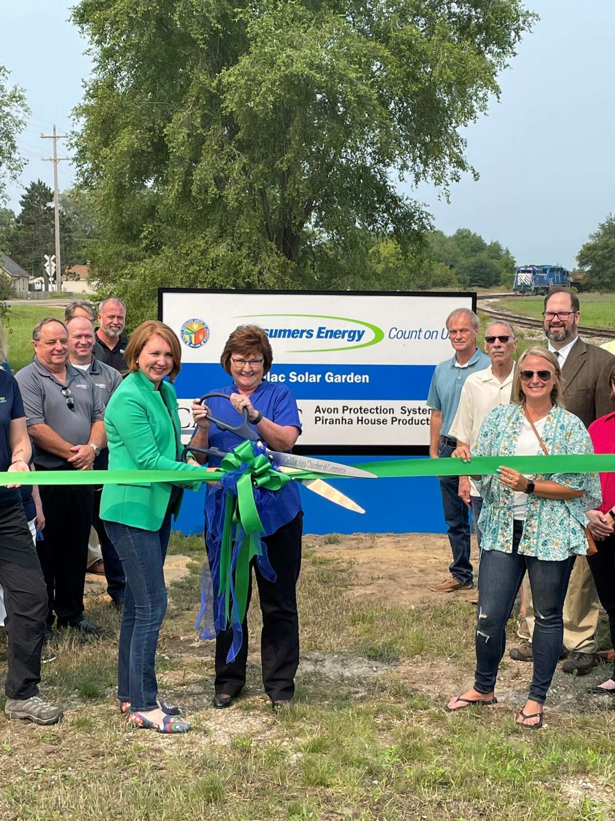 Front, from left, Consumer Energy VP of Costumer Experience Lauren Youngdahl Snyder, joins the mayor of Cadillac, Carla Filkins, to cut the Cadillac Solar Gardens ribbon. Also pictured are other leaders from Consumers Energy, the State of Michigan and the City of Cadillac.