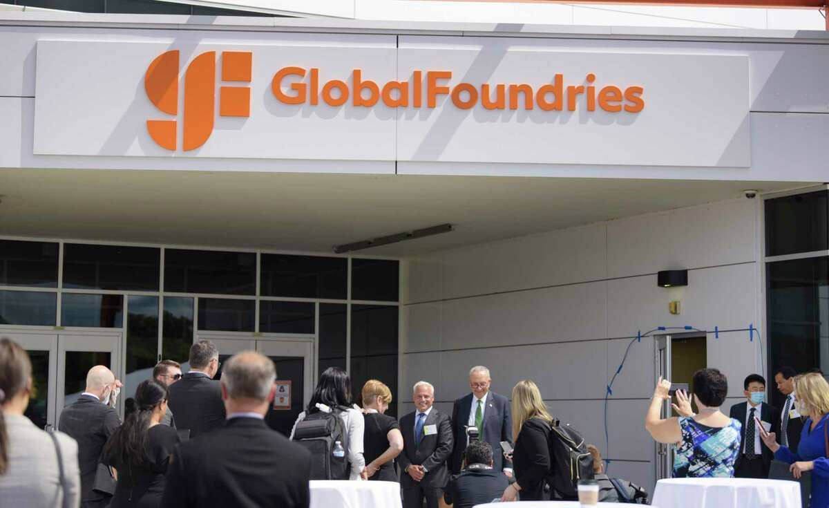 Globalfoundries CEO Tom Caulfield, background left, and Senate Majority Leader Charles Schumer, stop to pose for a photograph outside a building entrance at Globalfoundries at an event on Monday, July 19, 2021, in Malta, N.Y. Caulfield announced at the Monday event that a second chip plant will be built in Malta. (Paul Buckowski/Times Union)