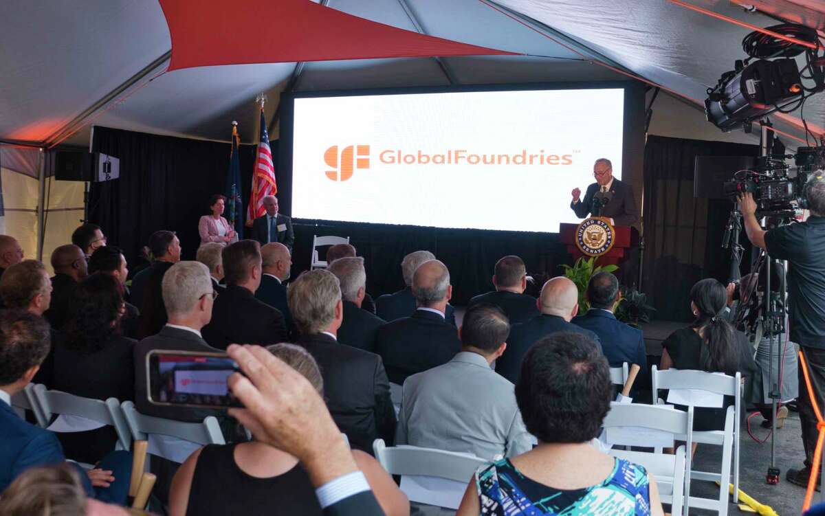 Senate Majority Leader Charles Schumer, right at podium, speaks at an event at Globalfoundries on Monday, July 19, 2021, in Malta, N.Y. Globalfoundries CEO Tom Caulfield announced on Monday that a second chip plant will be built in Malta. Seated on the stage to the left is U.S. Commerce Secretary Gina Raimondo, and Globalfoundries CEO Tom Caulfield. (Paul Buckowski/Times Union)