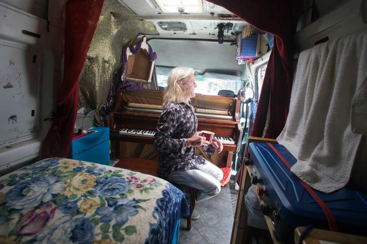 Brandy Collins, whose name is Mr. Brandy, is taking a break from playing the piano in the back of his Sprinter van in the Haight-Ashbury neighborhood of San Francisco on July 16, 2021.  The rear of his van is also his living quarters.