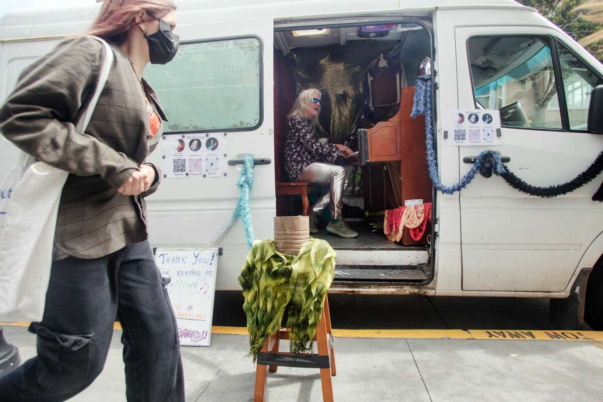 Brandy Collins, whose name is Mr. Brandy, plays a piano in his Sprinter van in the Haight-Ashbury neighborhood of San Francisco on July 16, 2021.